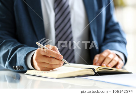 Male arm in suit and tie hold silver pen 106142574