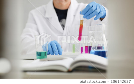 A male chemist holds test tube of glass A male chemist holds test tube of glass 106142627