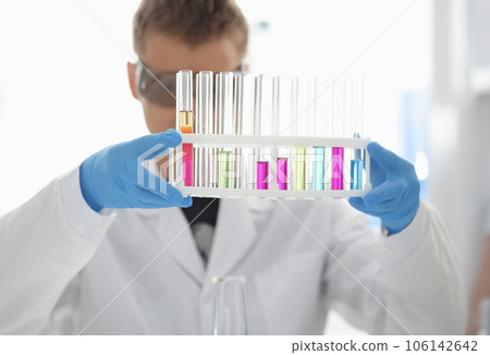 A male chemist holds test tube of glass A male chemist holds test tube of glass 106142642