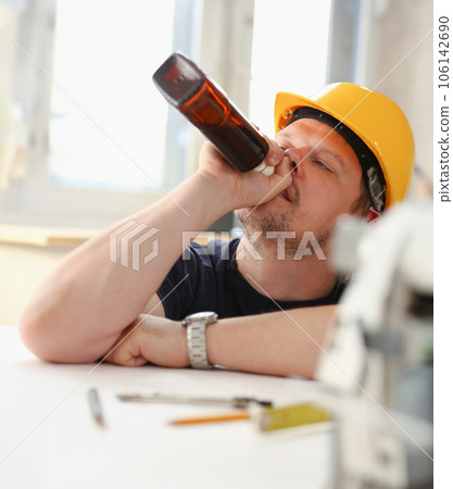 Arm of drunken worker in yellow helmet 106142690