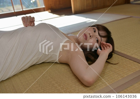 A young woman in a camisole lying in a Japanese-style room in an old folk house A young woman in a camisole lying in a Japanese-style room in an old folk house 106143036
