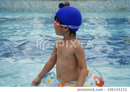 A kid swim in the pool. 106143152