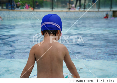 A kid swim in the pool. 106143155