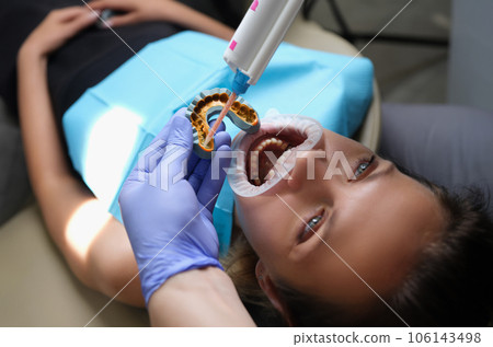 Orthodontist works with shape of jaw cast in process of prosthetics of facial arch of woman Orthodontist works with shape of jaw cast in process of prosthetics of facial arch of woman 106143498