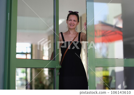 Smiling happy emotionally joyful young woman opens doors 106143610