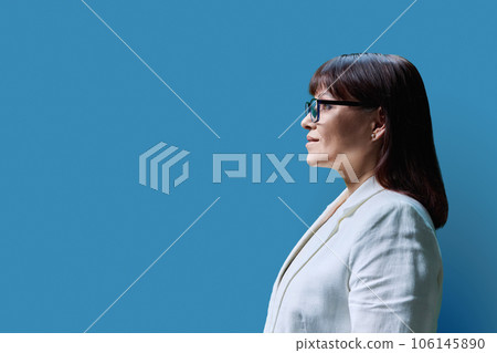 Serious mature business woman, profile view on blue studio background 106145890