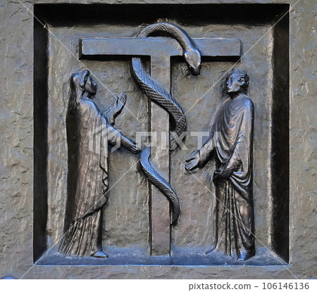 The redemptive death of Christ depicted in the emblem of the bronze serpent, relief on the door of the Grossmunster ("great minster") church in Zurich, Switzerland 106146136