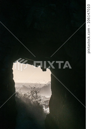Setting sun peeping through keyhole arch 106147010