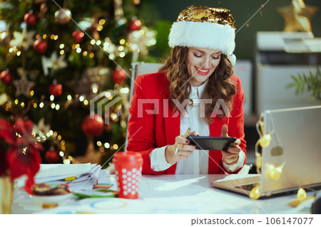 smiling elegant business woman using phone app and working 106147077