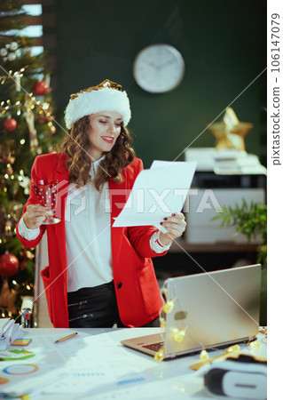 smiling business woman in green office with Christmas tree 106147079