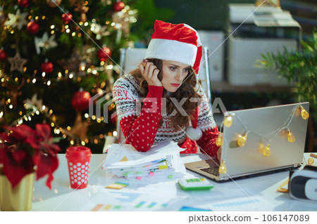 business woman in green office with Christmas tree working 106147089