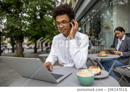 Young businessman with headphones working remotely and looking contented 106147618