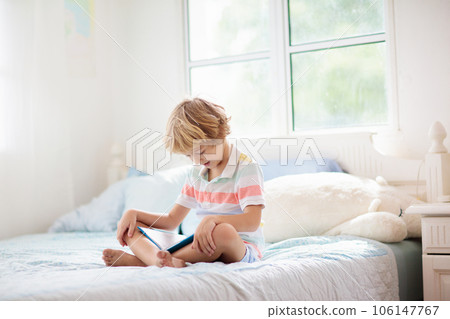 Child reading in bed. Kids read. Boy at home. 106147767