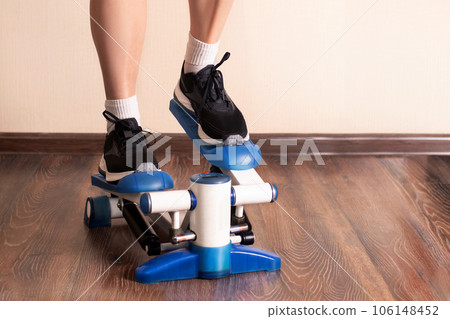 Home fitness. Woman doing exercises on stepper at home. close up photo 106148452