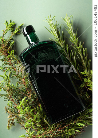 Vintage bottle with juniper and rosemary branches. 106148482