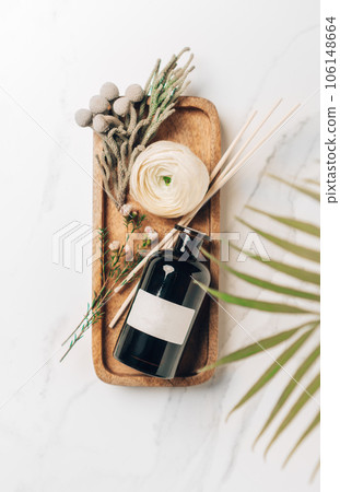 Scented home perfume with rattan sticks, luxury aroma oil with woody and flowers fragrance. Vertical, top view photography. 106148664