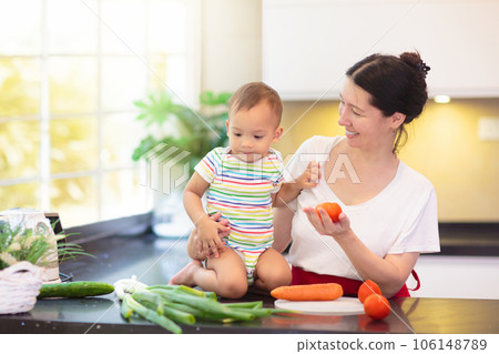 Mother and baby boy in white sunny kitchen 106148789