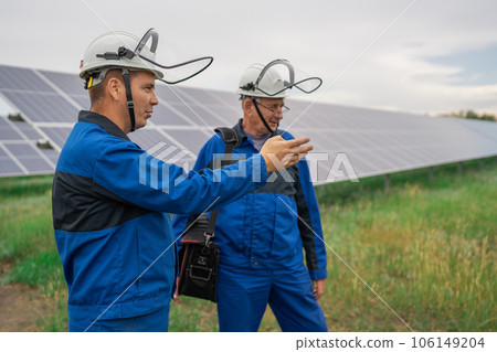 Service Engineer man standing with arms crossed in front of solar panels. Technician maintenance solar cells on Solar Energy Plant under morning sunlight. Technology solar energy renewable 106149204