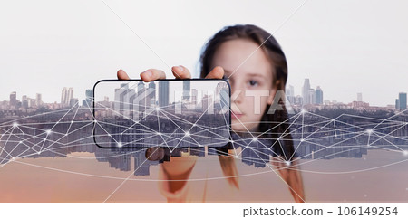 Smartphone in hand of child girl on modern city background 106149254