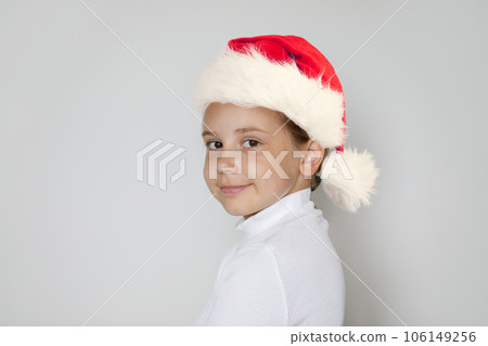Christmas kid in Santa hat. Happy Xmas child girl Santa on white background Christmas kid in Santa hat. Happy Xmas child girl Santa on white background 106149256
