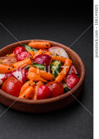 Delicious fresh juicy salad with radishes, tomatoes, carrots, cucumber, spices and herbs 106149805
