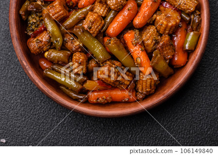 Mix of vegetables corn, carrots, peppers, broccoli, onions in teriyaki sauce on a ceramic plate 106149840