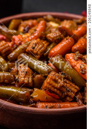 Mix of vegetables corn, carrots, peppers, broccoli, onions in teriyaki sauce on a ceramic plate 106149848