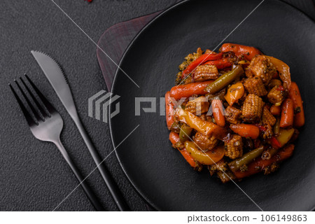 Mix of vegetables corn, carrots, peppers, broccoli, onions in teriyaki sauce on a ceramic plate 106149863