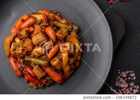 Mix of vegetables corn, carrots, peppers, broccoli, onions in teriyaki sauce on a ceramic plate 106149872
