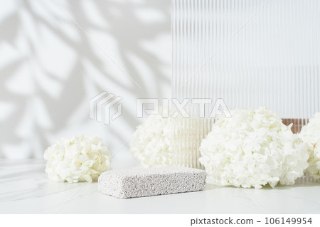Beauty and cosmetics product presentation scene with pumice stone podium and white spring flowers Beauty and cosmetics product presentation scene with pumice stone podium and white spring flowers 106149954