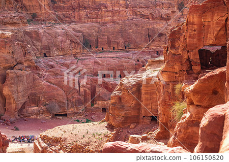View of the wall with the door, the entrance to the temple, carved into the red sandstone rock in the canyon. Petra, Jordan 106150820