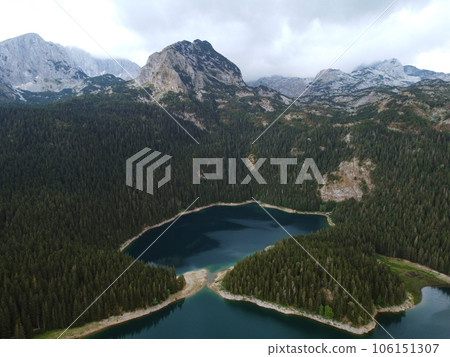 Amazing aerial drone view of Crno Jezero or Black lake, pine forest and cliffs in Durmitor national park, Zabljak, Montenegro. Travel, environment, beauty in nature, relaxing. UNESCO World Heritage Amazing aerial drone view of Crno Jezero or Black lake, pine forest and cliffs in Durmitor national park, Zabljak, Montenegro. Travel, environment, beauty in nature, relaxing. UNESCO World Heritage 106151307