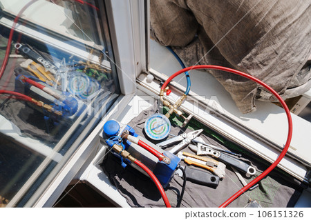 without a face. A man installs an external air conditioner. dangerous work. without a face. A man installs an external air conditioner. dangerous work. 106151326