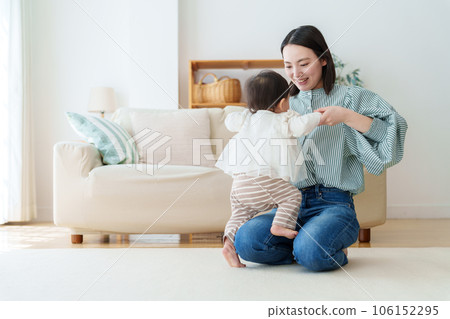 mother playing with baby in living room 106152295