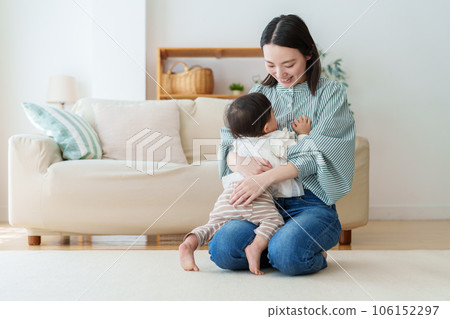 mother playing with baby in living room 106152297