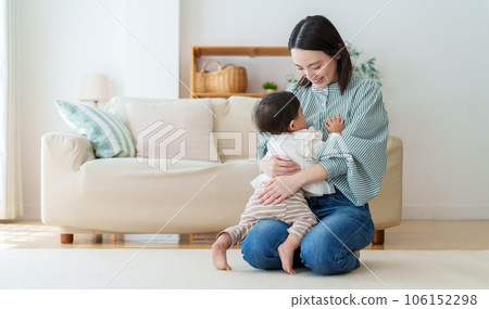mother playing with baby in living room 106152298