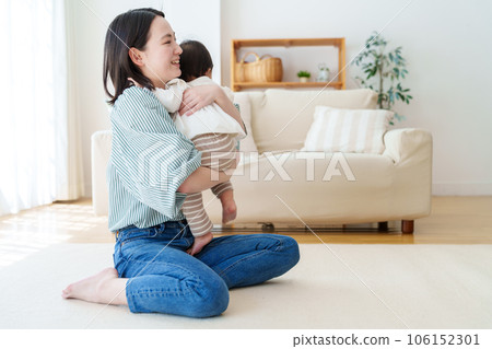 mother playing with baby in living room 106152301