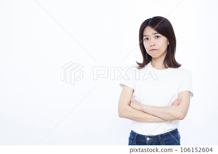 A woman in her thirties who is worried in front of a white background A woman in her thirties who is worried in front of a white background 106152604