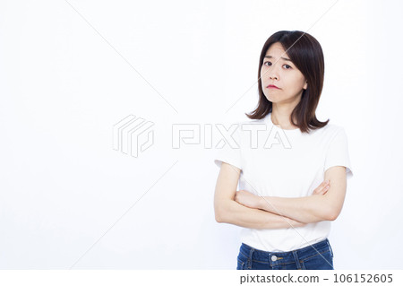 A woman in her thirties who is worried in front of a white background A woman in her thirties who is worried in front of a white background 106152605