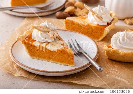 Pumpkin cheesecake swirl pie topped with whipped cream Pumpkin cheesecake swirl pie topped with whipped cream 106153056