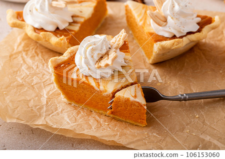 Pumpkin cheesecake swirl pie topped with whipped cream Pumpkin cheesecake swirl pie topped with whipped cream 106153060
