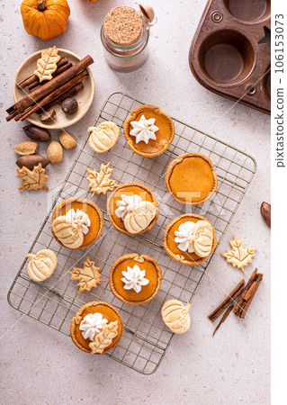 Mini pumpkin pies with wipped cream and cinnamon Mini pumpkin pies with wipped cream and cinnamon 106153073