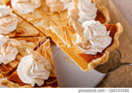 Pumpkin cheesecake swirl pie topped with whipped cream 106153080