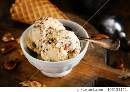 Butter pecan ice cream in a white bowl 106153151