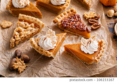 Variety of Thanksgiving pie slices on parchment paper 106153167