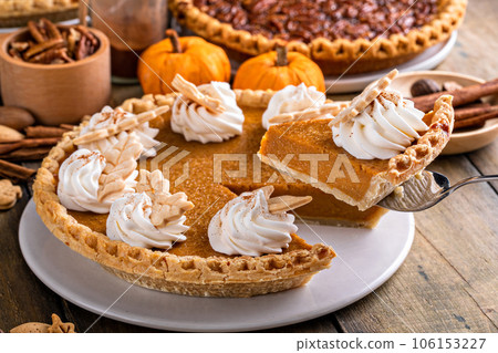 Traditional Thanksgiving pumpkin pie topped with whipped cream Traditional Thanksgiving pumpkin pie topped with whipped cream 106153227