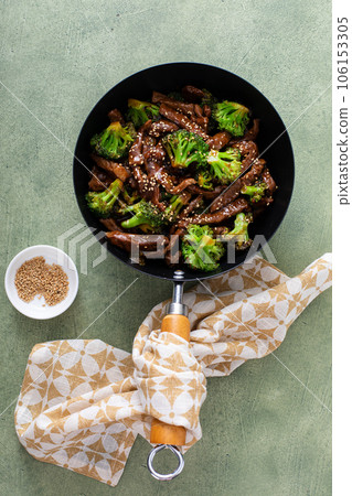 Beef and broccoli stir fry in a small wok 106153305
