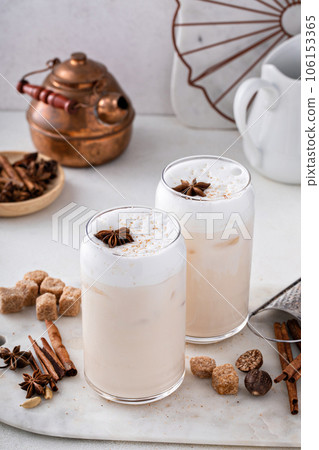 Iced chai latte with warm winter spices topped with milk foam Iced chai latte with warm winter spices topped with milk foam 106153365