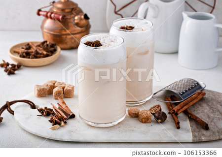 Iced chai latte with warm winter spices topped with milk foam 106153366