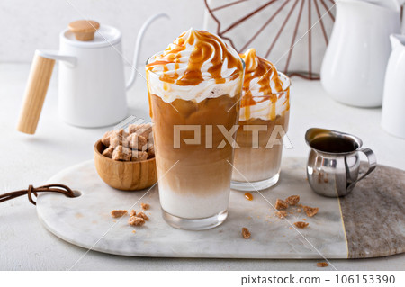 Iced caramel latte topped with whipped cream and caramel sauce 106153390